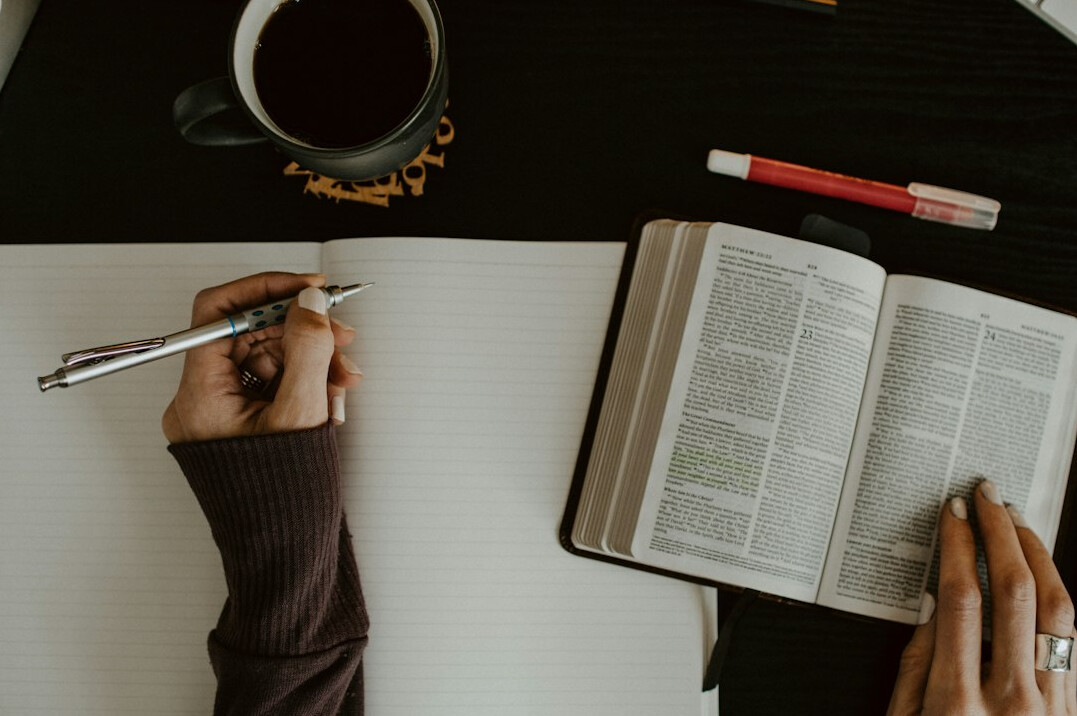 person writing notes in journal