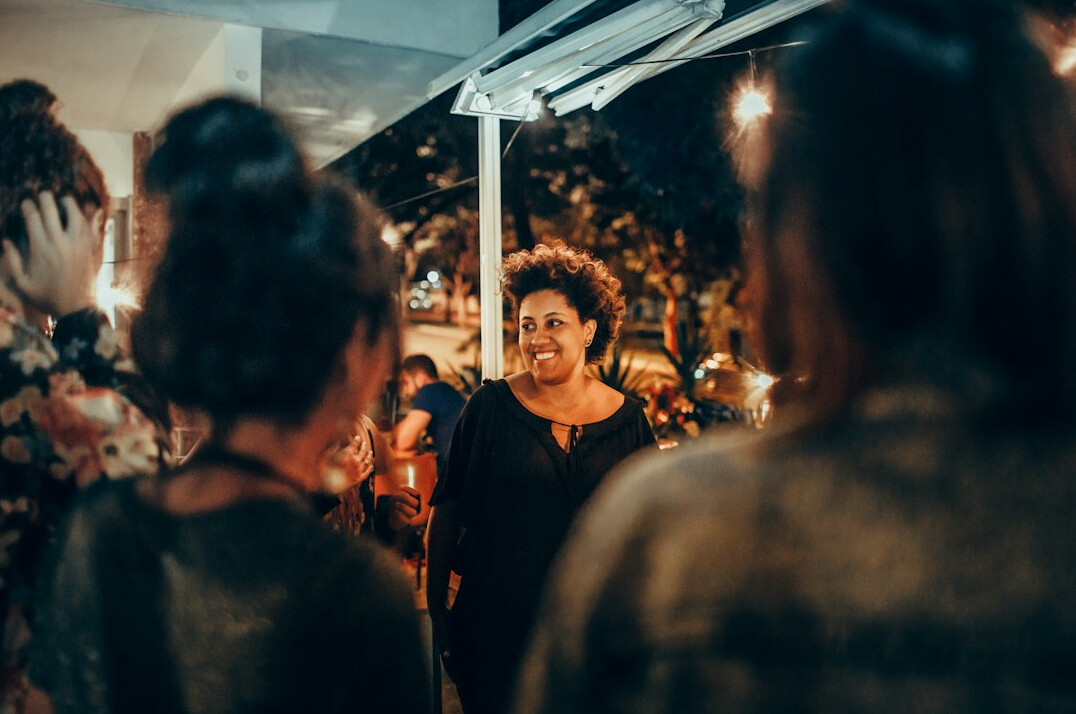 Mexican woman speaking confidently to a small group in a bright room